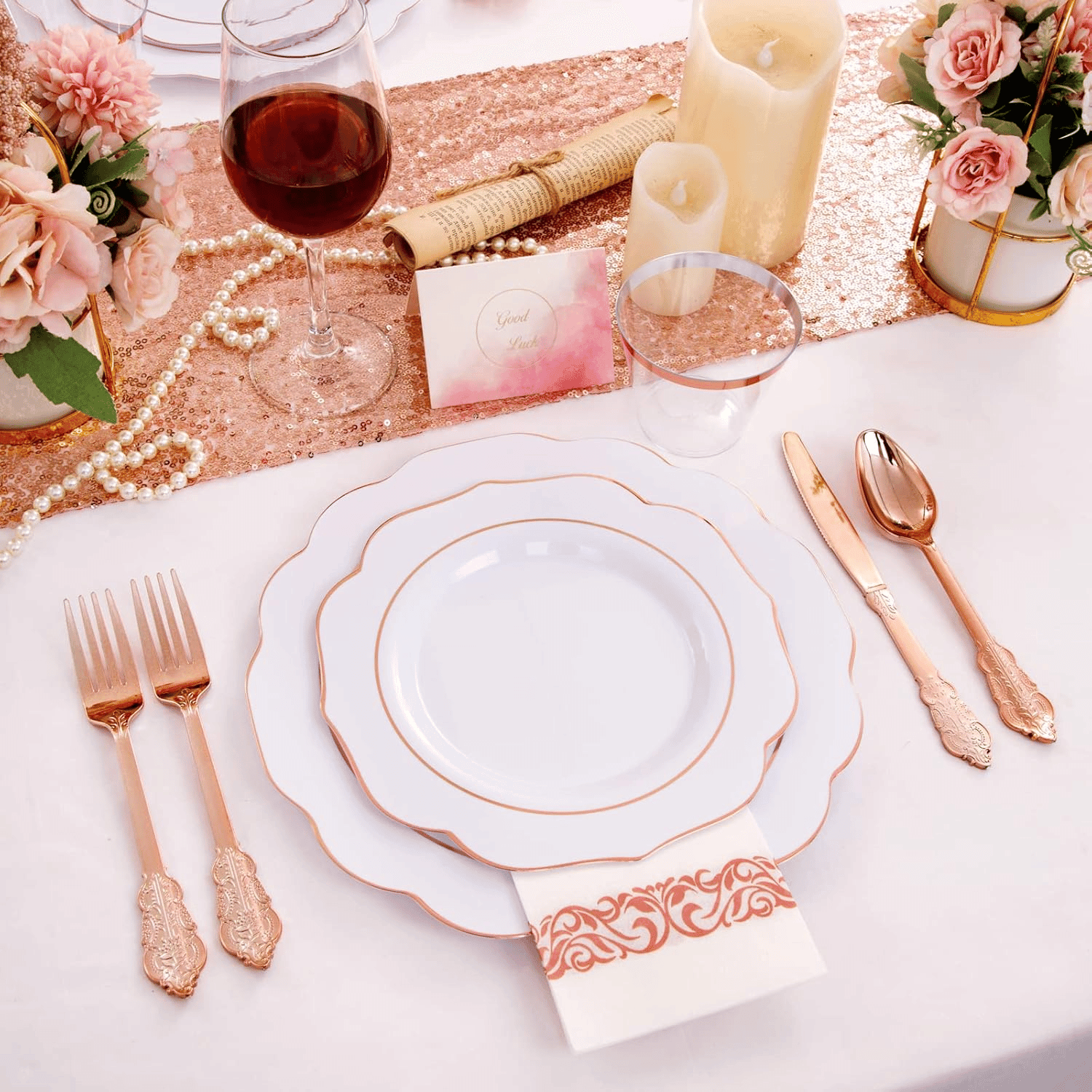 Scalloped plastic plates with rose gold rims, rose gold cutlery and a printed napkin on a wedding table