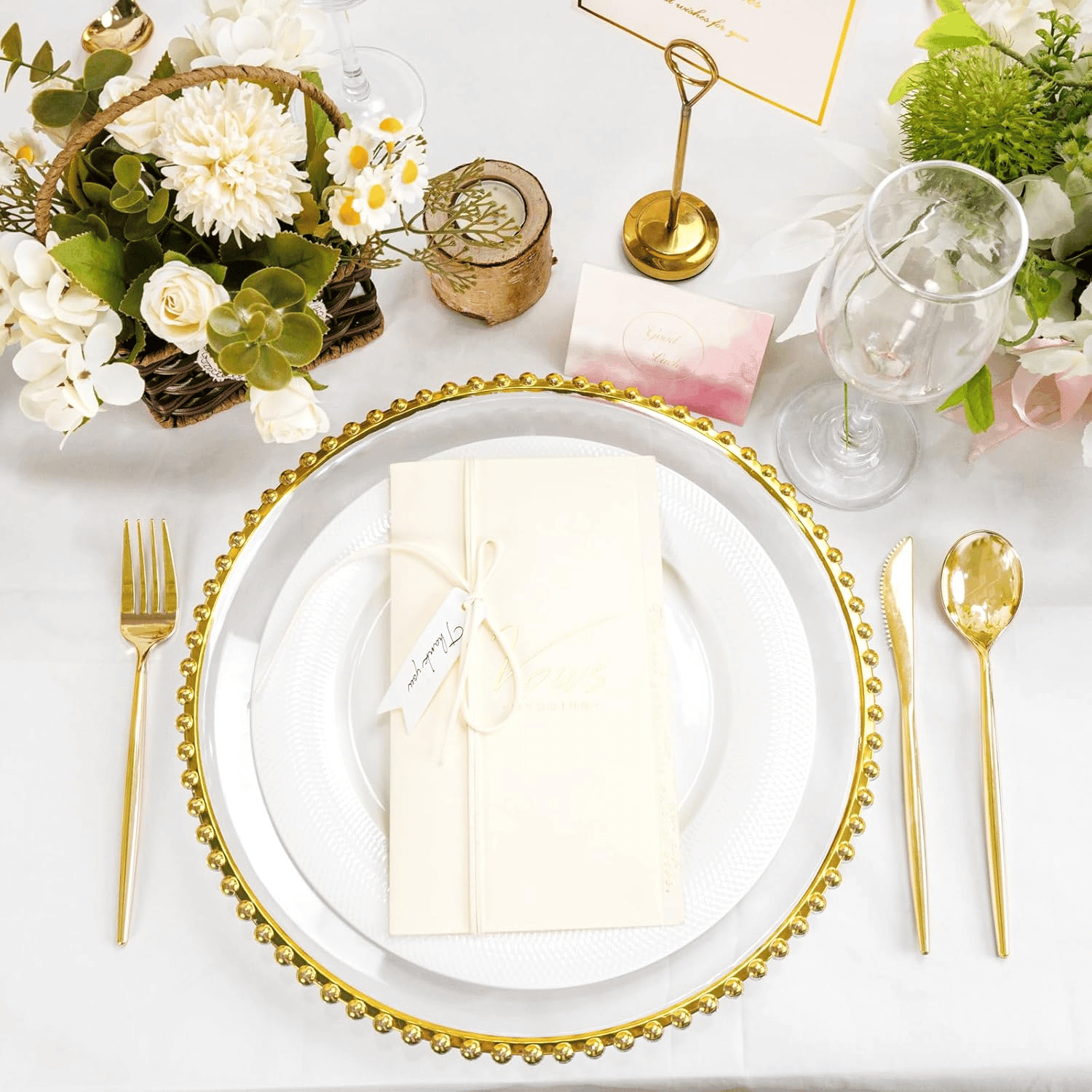 Clear charger plate with a gold beaded rim, set with a folded napkin and gold cutlery